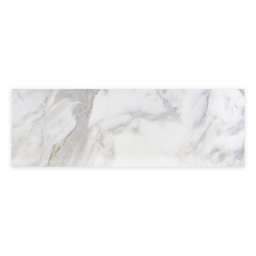 Overhead view of Calacatta Gold Marble 4x12 honed tile, displaying smooth texture and warm veining perfect for walls or backsplashes.