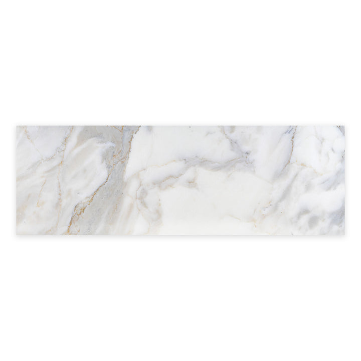 Overhead view of Calacatta Gold Marble 4x12 honed tile, displaying smooth texture and warm veining perfect for walls or backsplashes.