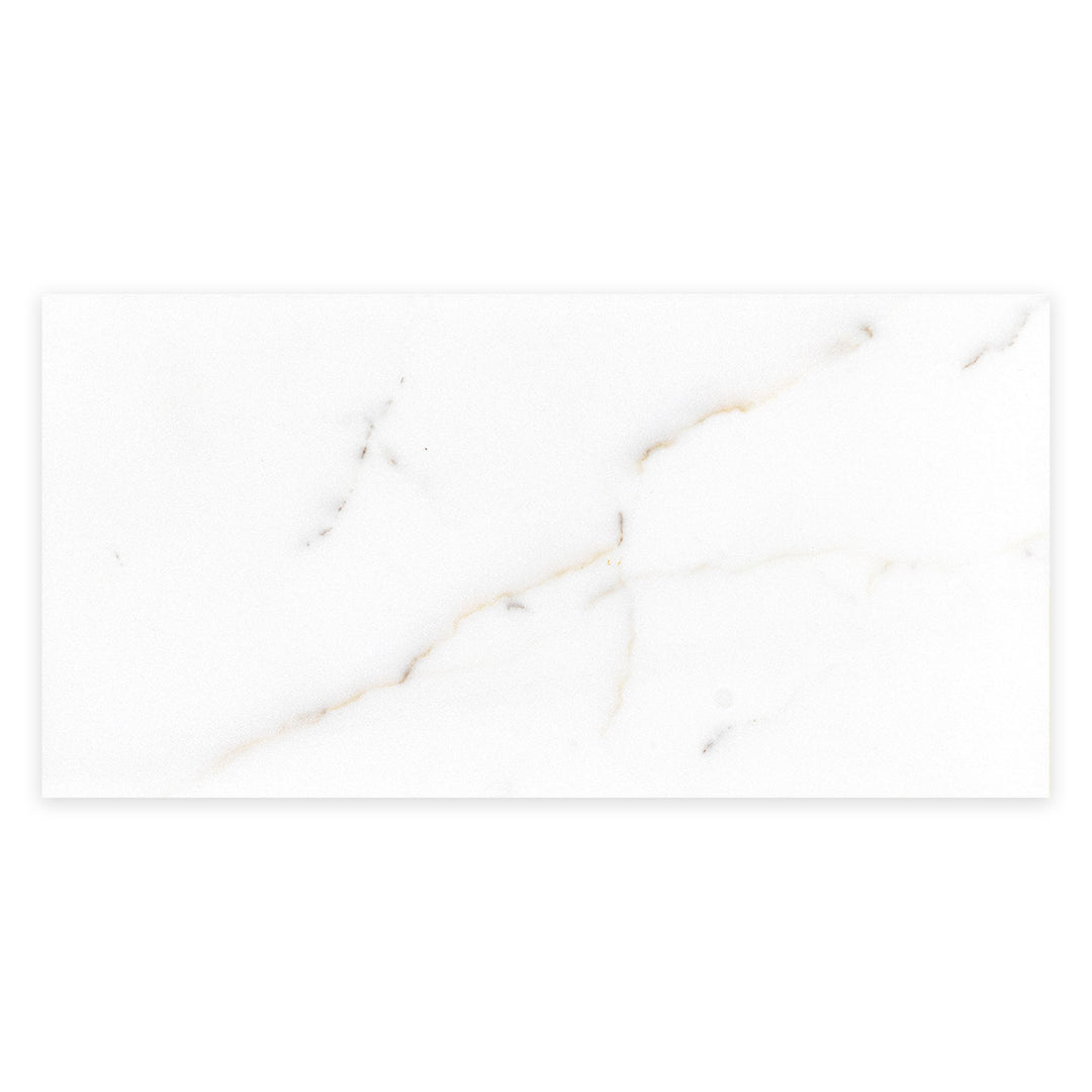 From a top-down perspective, this 6x12 honed Calacatta Gold Marble tile reveals soft white tones enhanced by natural gold veining.