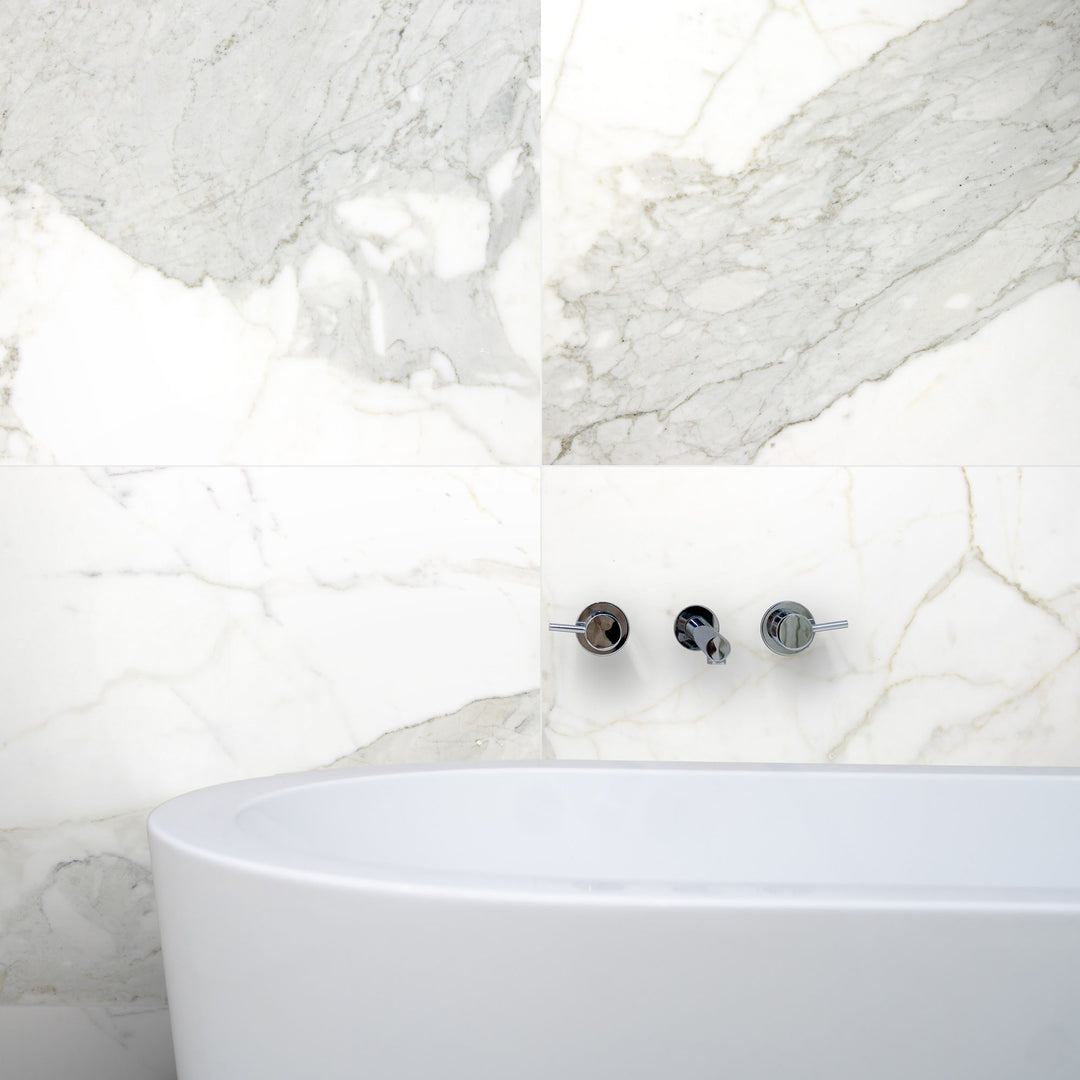 Lifestyle image of Calacatta Gold Marble 24x24 Honed Tile installed on the floor, showcasing luxurious white marble with bold gold veining in an upscale interior setting.