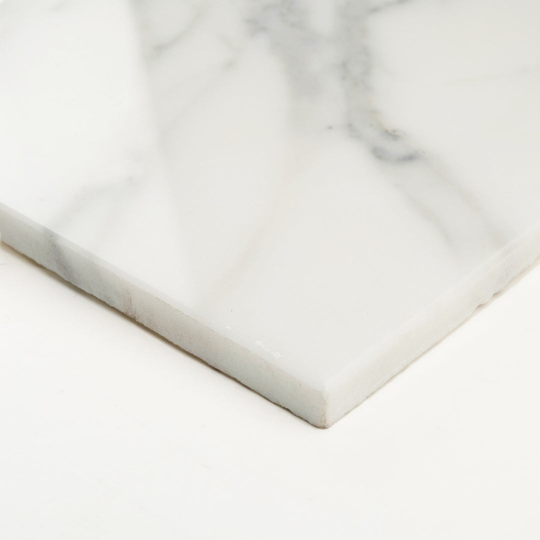Calacatta Gold Marble 24x24 polished tile captured from the corner, emphasizing its radiant surface and bold marble patterning.