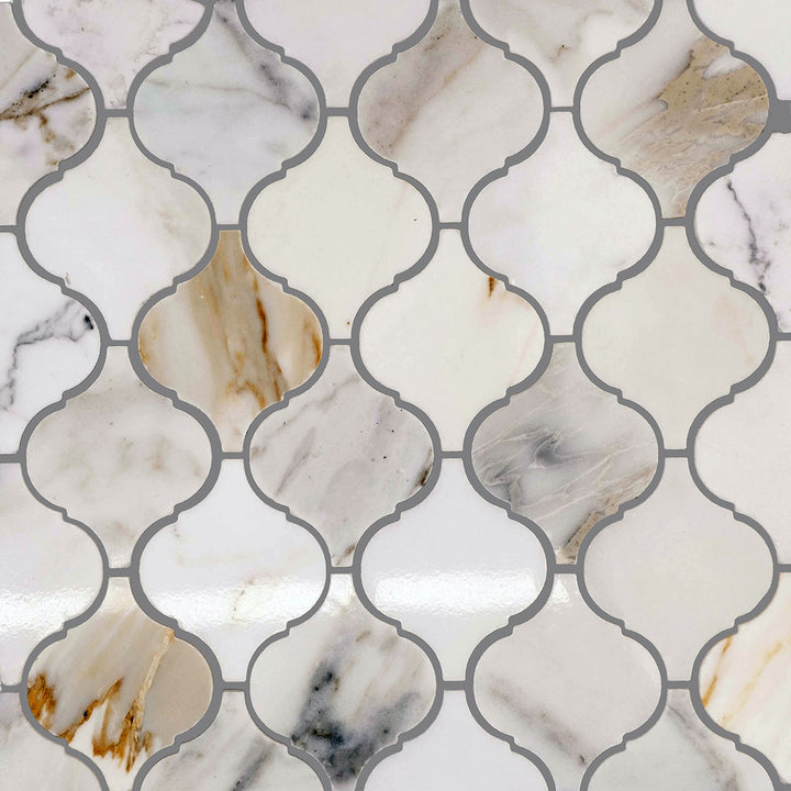 Top arrangement of Calacatta Gold Marble 4" Lantern/Arabesque honed mosaic pieces showing interlocking layout.