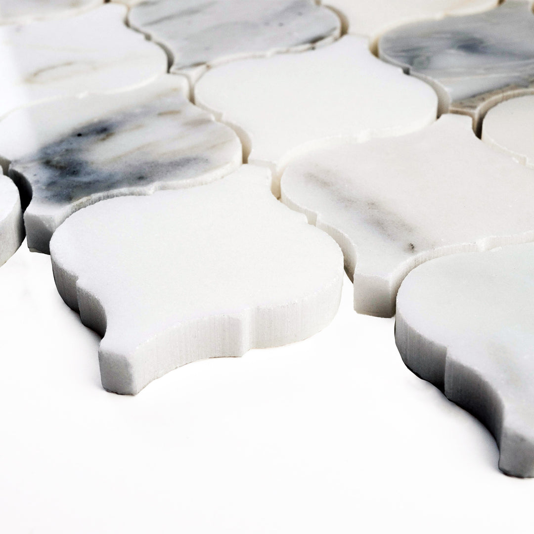 Corner perspective of 4" Lantern/Arabesque Calacatta Gold honed mosaic, featuring classic shapes with a velvety texture and warm veining.