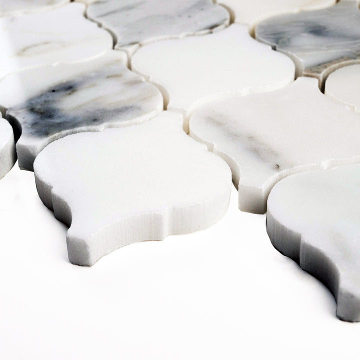 Corner perspective of 4" Lantern/Arabesque Calacatta Gold honed mosaic, featuring classic shapes with a velvety texture and warm veining.