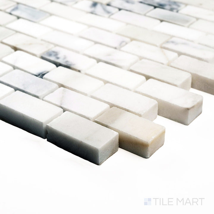 Polished Calacatta Gold 5/8x1-1/4 brick mosaic shown from a corner angle, featuring luminous mini bricks with distinctive golden veining.