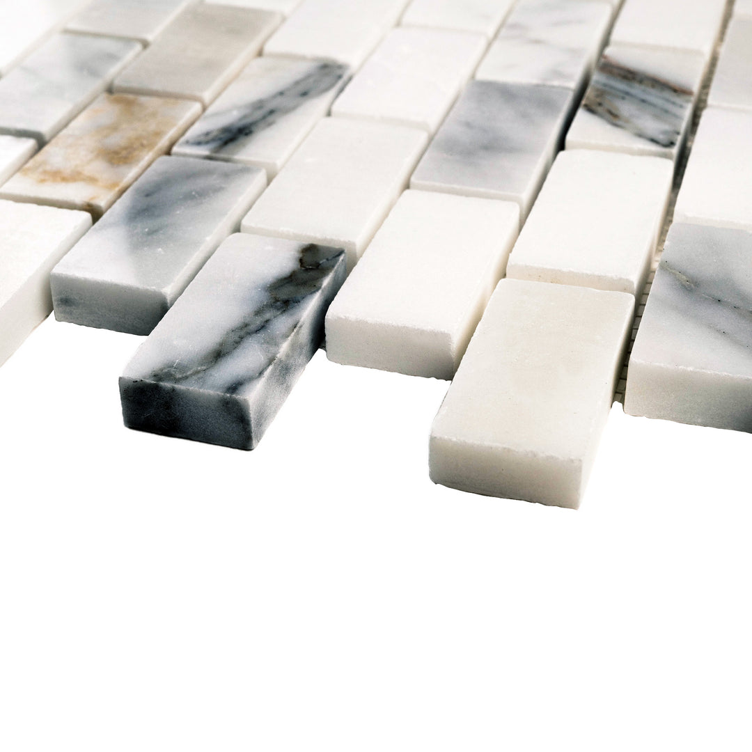 Corner shot of 1x2 Calacatta Gold brick mosaic in polished finish, emphasizing a reflective surface that enhances its warm gold and grey veining.