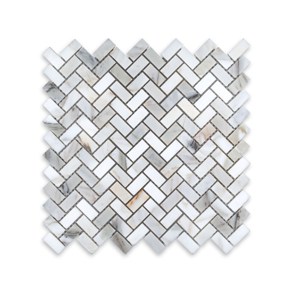 This 5/8 by 1-1/4 herringbone mosaic in honed Calacatta Gold Marble is displayed from above, showcasing tight pattern work and subtle matte texture.