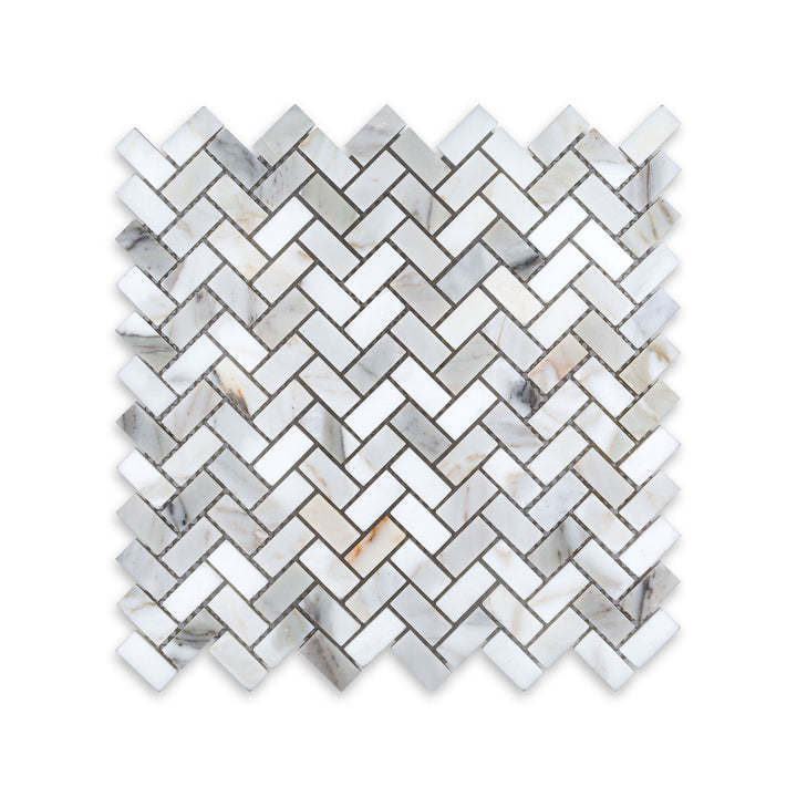 This 5/8 by 1-1/4 herringbone mosaic in honed Calacatta Gold Marble is displayed from above, showcasing tight pattern work and subtle matte texture.