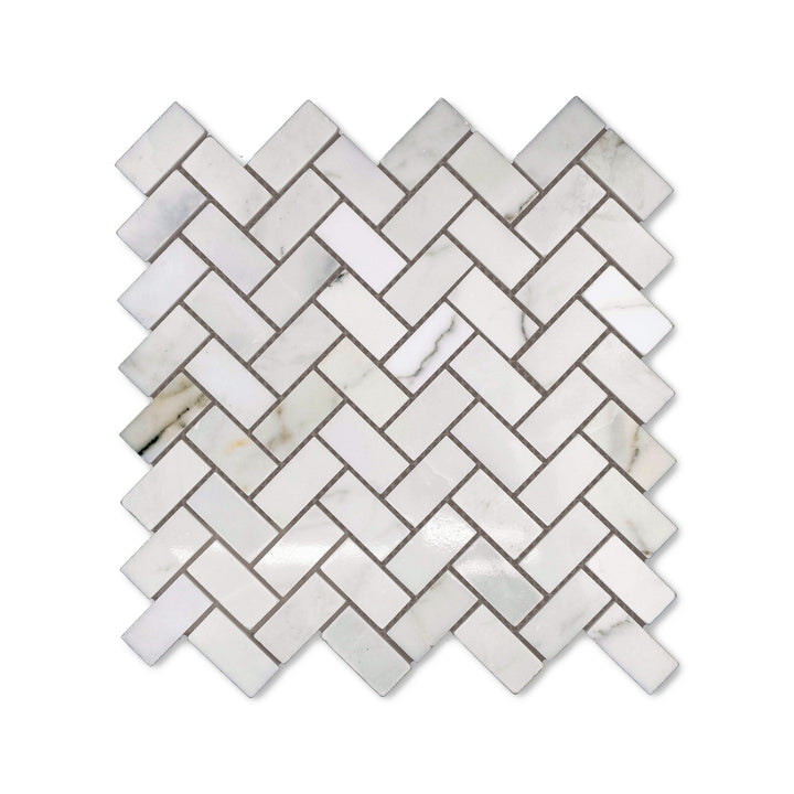 Polished finish gives this 1x2 Calacatta Gold Marble herringbone mosaic a radiant surface, captured from above to highlight the classic marble styling.