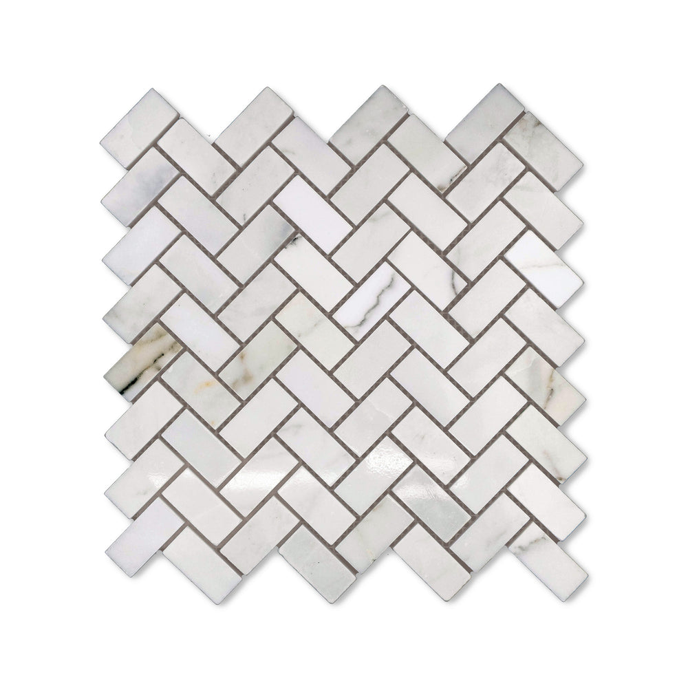 Polished finish gives this 1x2 Calacatta Gold Marble herringbone mosaic a radiant surface, captured from above to highlight the classic marble styling.