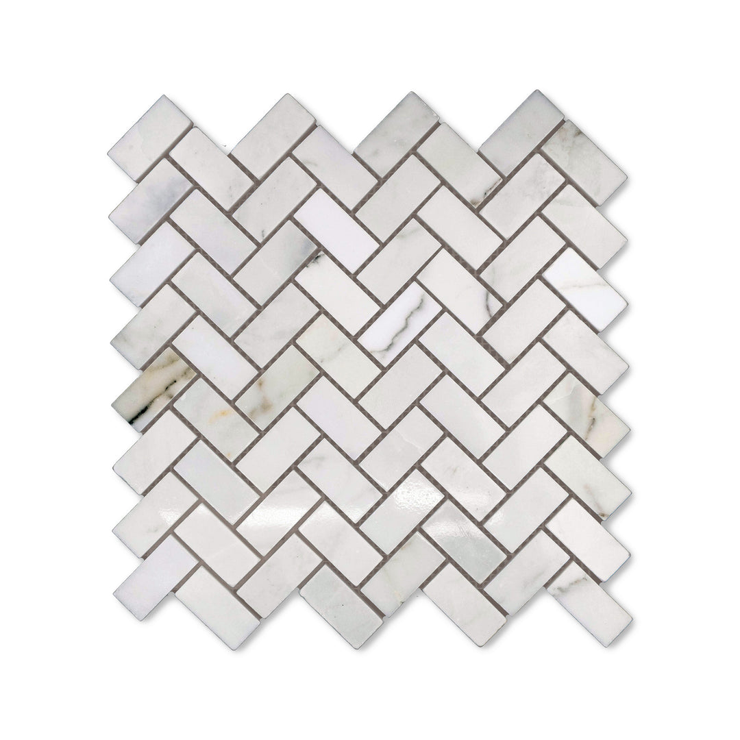 Polished finish gives this 1x2 Calacatta Gold Marble herringbone mosaic a radiant surface, captured from above to highlight the classic marble styling.