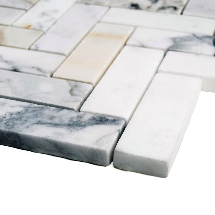 Corner shot of Calacatta Gold 1x3 herringbone mosaic in a honed finish, offering a refined matte surface and a stretched, sophisticated layout.