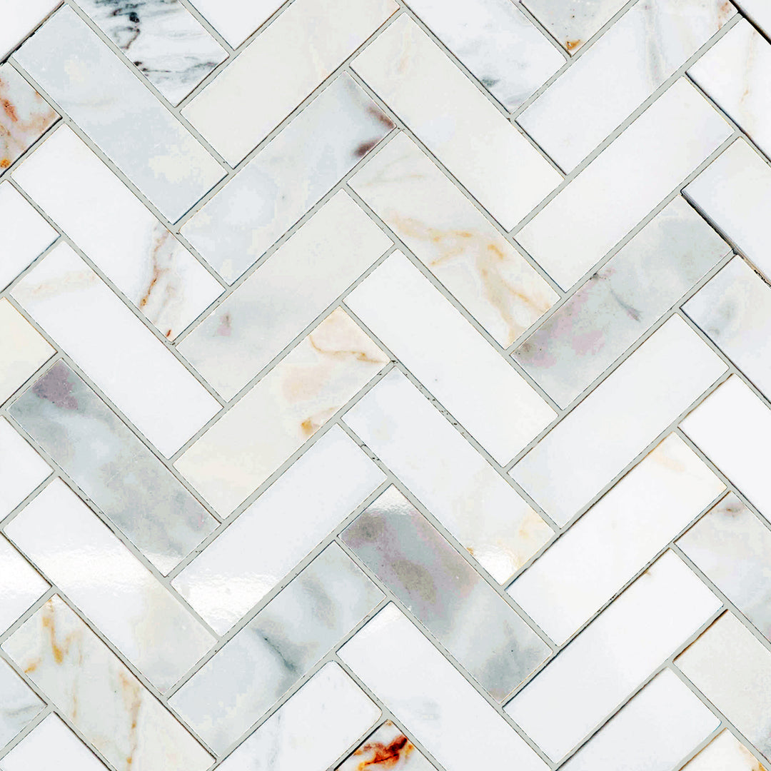 Calacatta Gold Marble 1x3 herringbone polished mosaic presented in an angled layout with glossy texture and elegant curves.