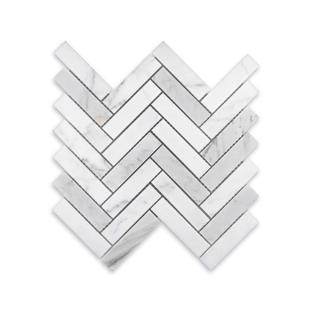 Overhead view of honed Calacatta Gold Marble 1x4 herringbone mosaic, showcasing elongated pieces and warm veining in a classic interlocking pattern.