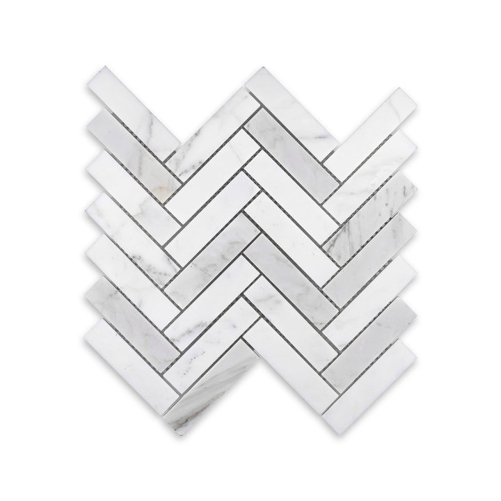 Overhead view of honed Calacatta Gold Marble 1x4 herringbone mosaic, showcasing elongated pieces and warm veining in a classic interlocking pattern.