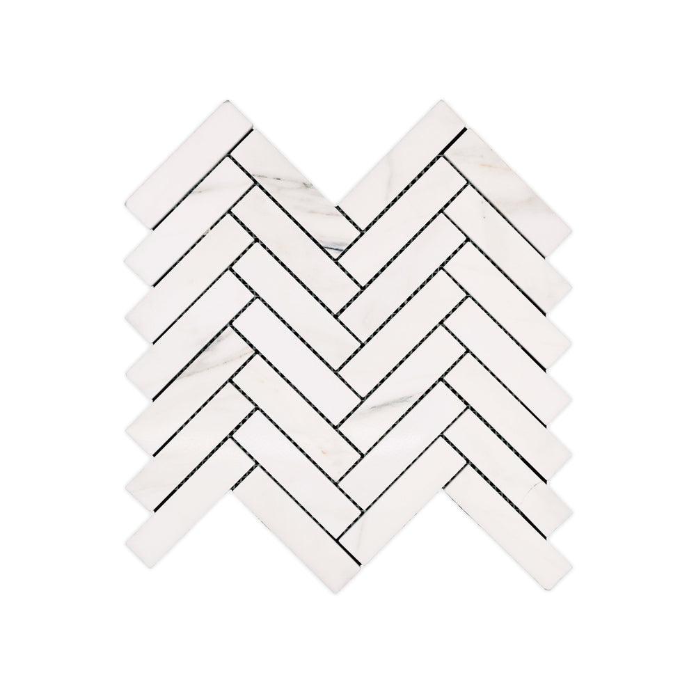 This top-view shot of polished 1x4 Calacatta Gold Marble herringbone mosaic reveals luxurious detail and brilliant veining across a sleek marble surface.