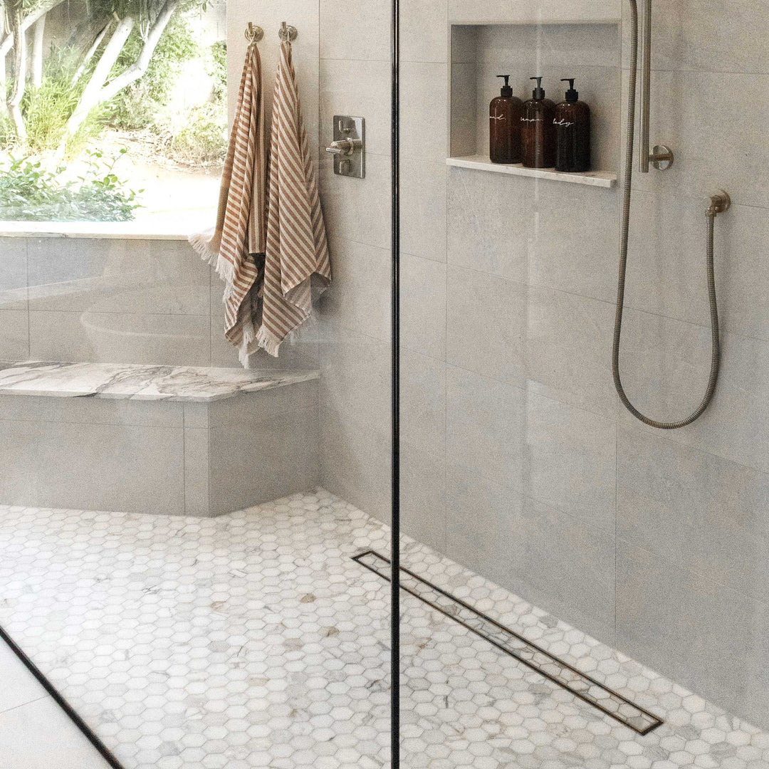 Modern bathroom with shower area, towels, and toiletries.