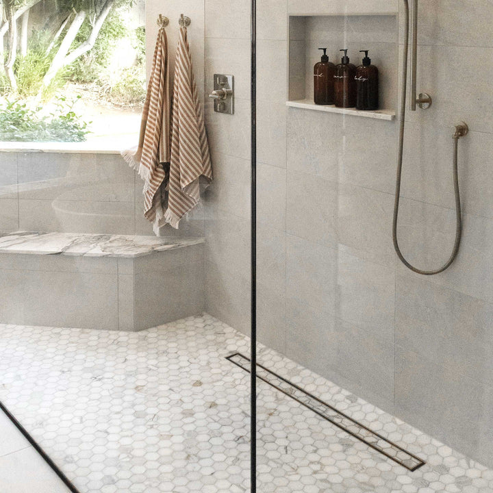 Modern bathroom with shower area, towels, and toiletries.