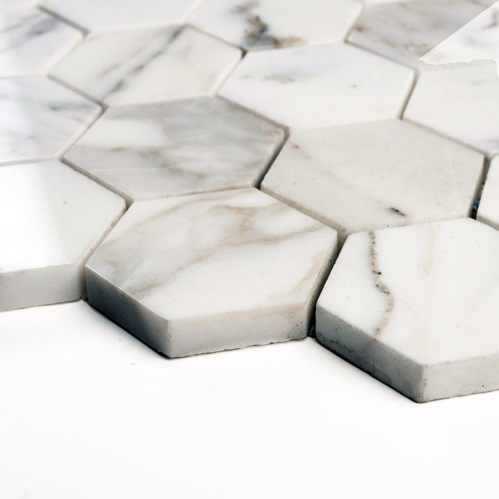 Polished Calacatta Gold 2" hexagon mosaic shot from a side perspective, with glossy tiles that reflect depth and intricate golden swirls.