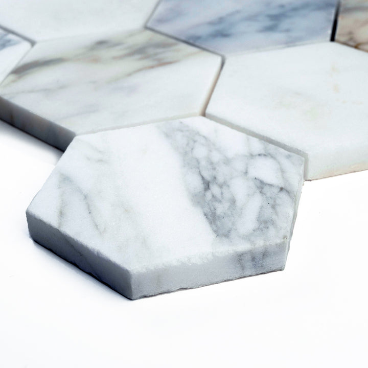 Corner-captured 3" hexagon mosaic in Calacatta Gold honed marble, offering a sleek layout with a clean matte sheen and graceful stone variations.
