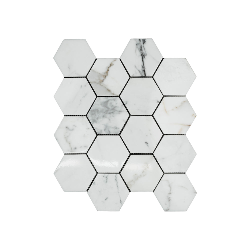 This top-down shot captures the polished Calacatta Gold Marble 3 inch hexagon mosaic, highlighting the natural shine and dramatic gold veining.