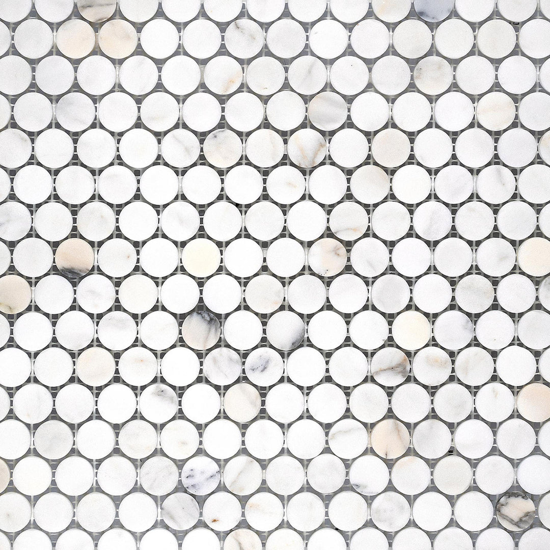 Calacatta Gold Marble penny round honed mosaic tiles laid out in a classic circular grid with a soft matte finish.