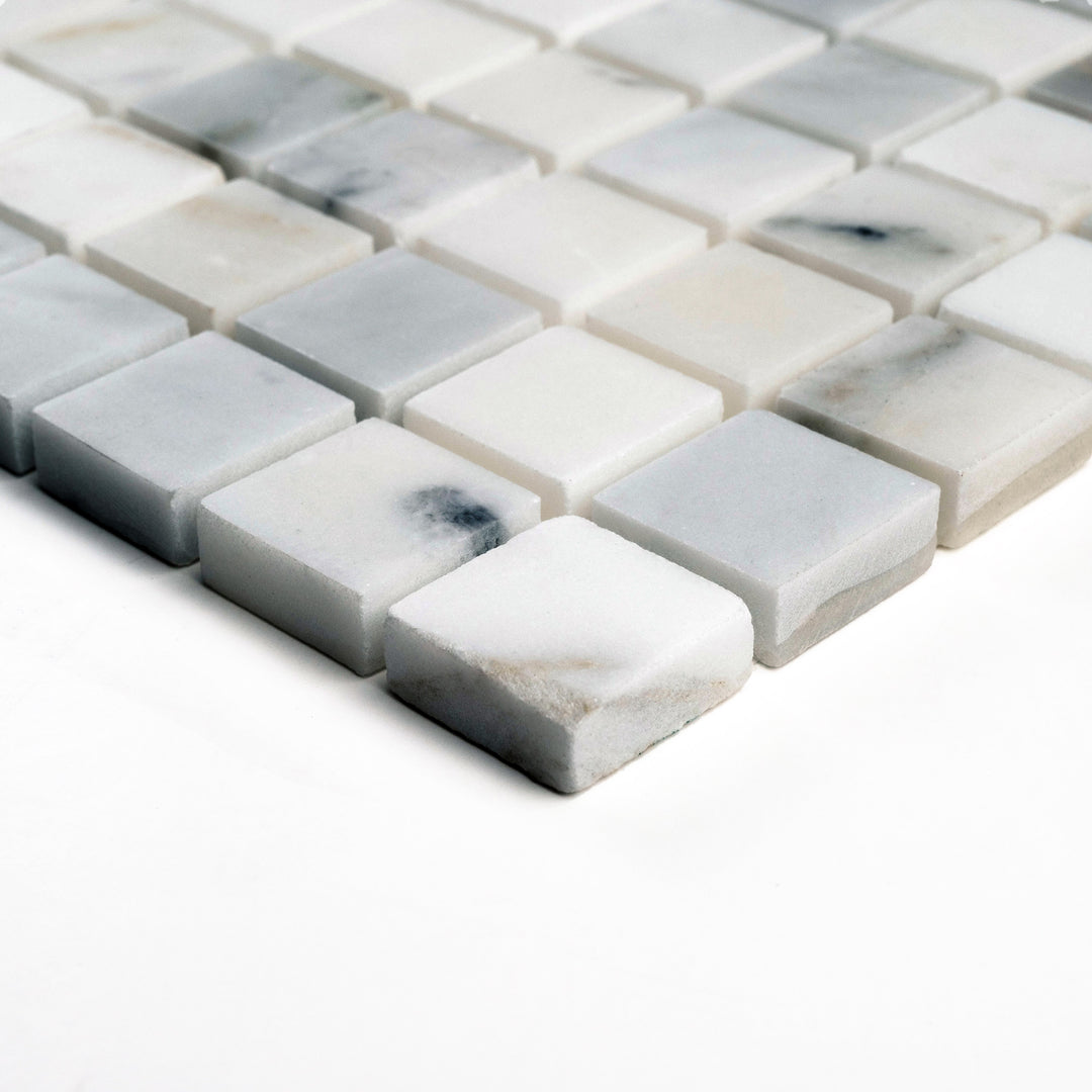 Corner view of honed 1" square Calacatta Gold mosaic, offering a soft sheen and an understated luxury in compact tile arrangement.