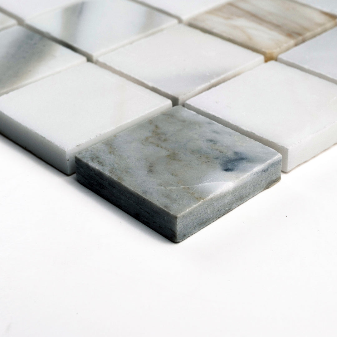 Honed 2" square Calacatta Gold mosaic viewed at an angle, presenting a clean layout with warm veining across each tile.