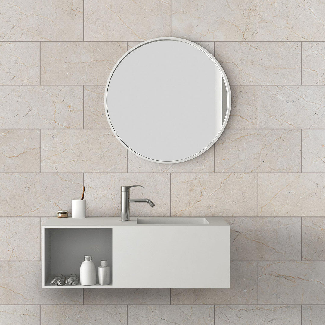 Bathroom vanity with round mirror on tiled wall