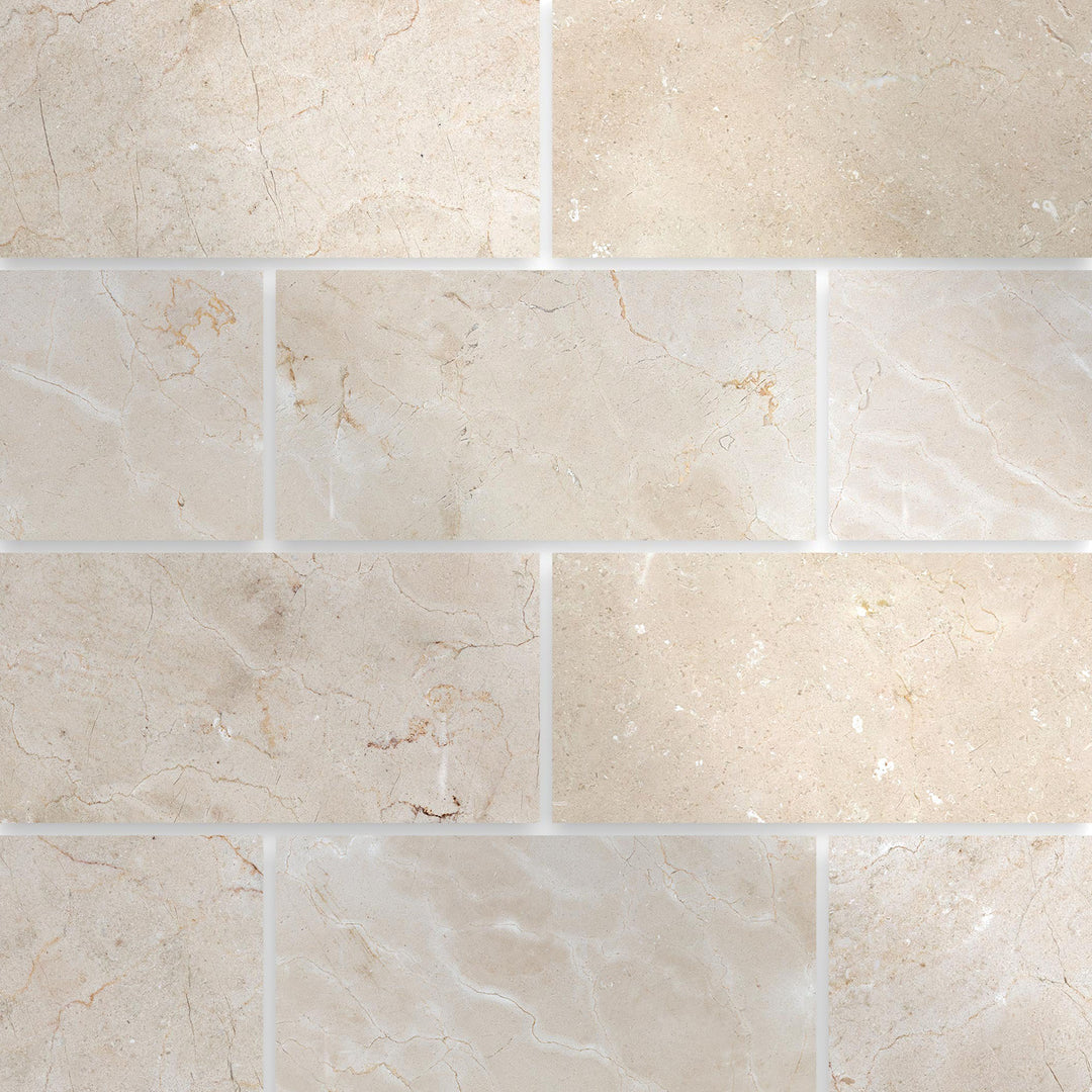 Polished 3x6 Crema Marfil Classic Marble tiles arranged in a grid to highlight the reflective surface and cream veining.