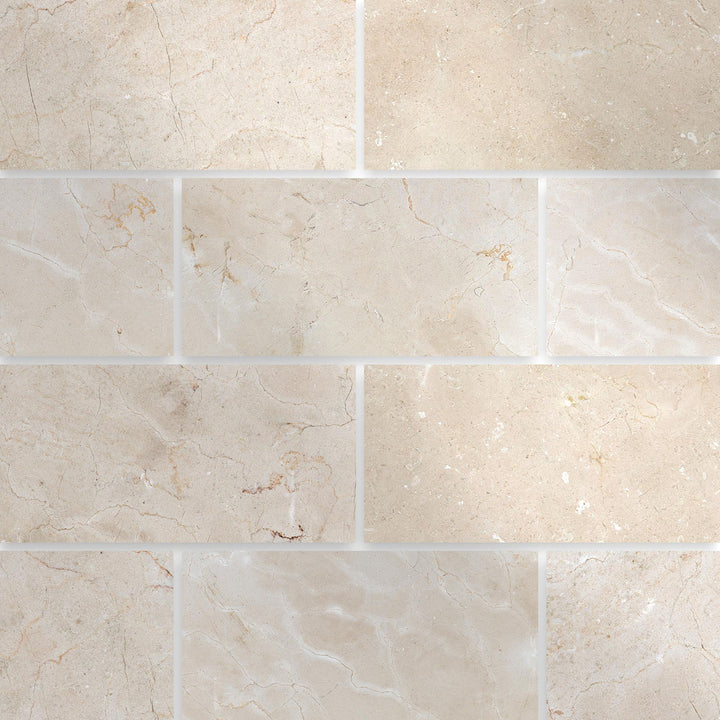 Polished 3x6 Crema Marfil Classic Marble tiles arranged in a grid to highlight the reflective surface and cream veining.