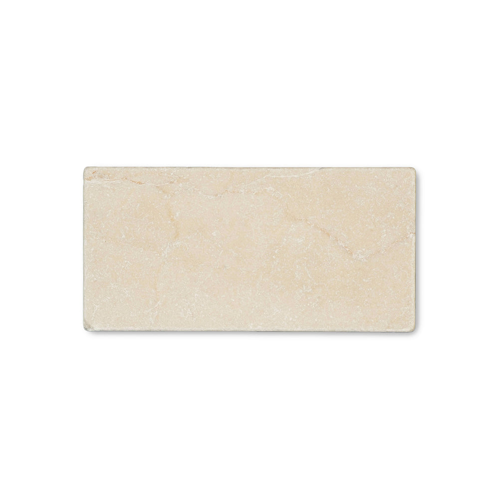Seen from above, the Crema Marfil Classic Marble 3x6 tumbled tile showcases a textured, rustic finish with soft edges and warm neutral color.