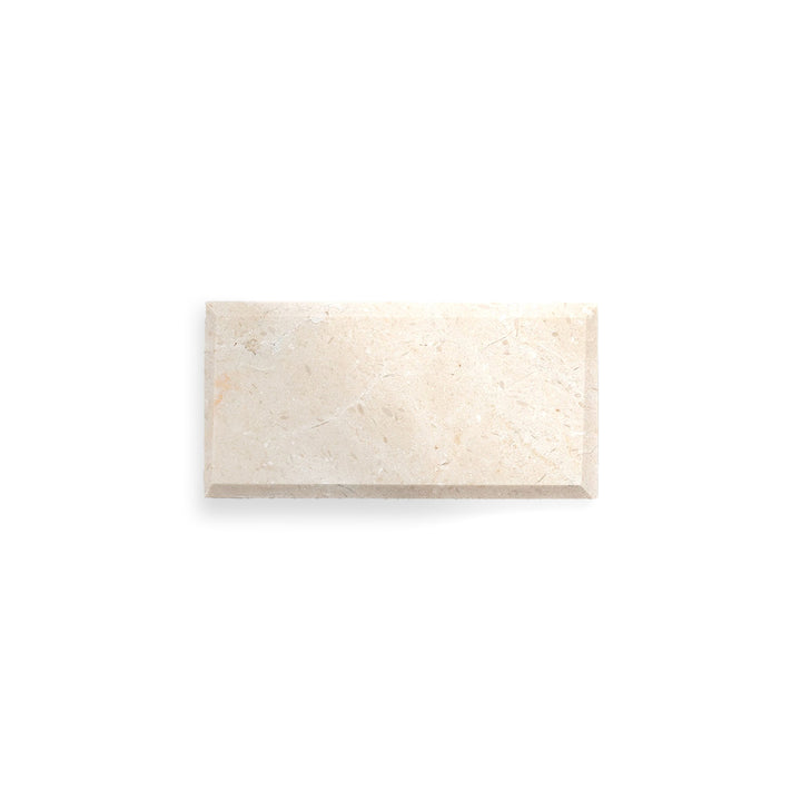 Overhead shot of Crema Marfil Classic Marble 3x6 beveled tile in a polished finish, combining glossy texture with decorative edge styling.