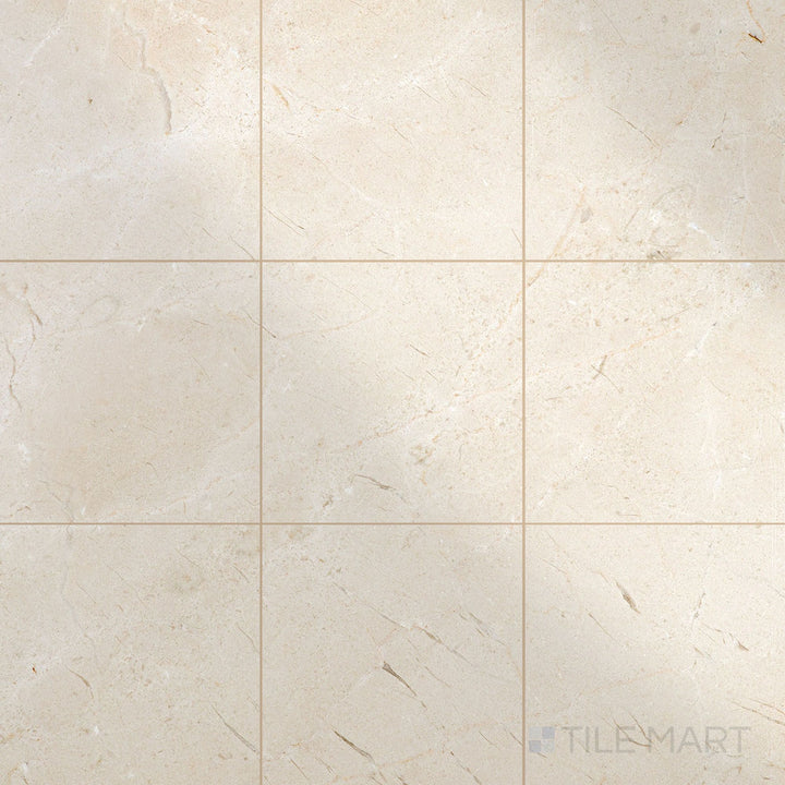 Glossy 12x12 polished Crema Marfil Select Marble tiles arranged to capture light and enhance classic stone texture.