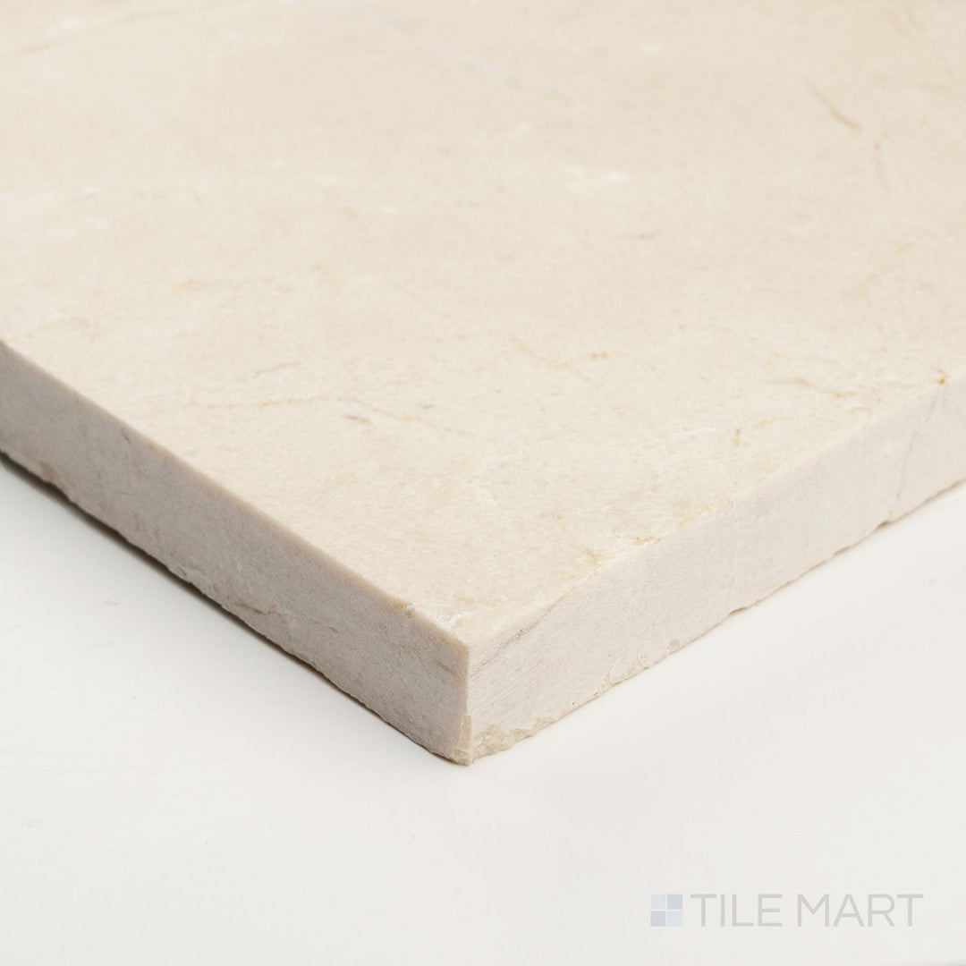 Corner close-up of Crema Marfil Select Marble 24x24 honed tile showing smooth matte finish and subtle creamy variation.