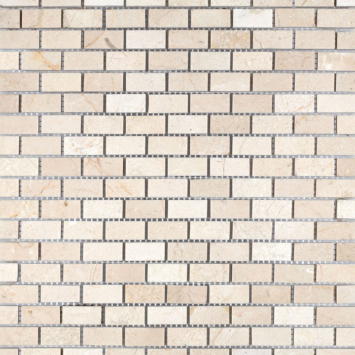 Overview of Crema Marfil Marble 5/8x1-1/4 honed brick mosaic tiles aligned in rows to exhibit uniform matte texture and creamy hue.