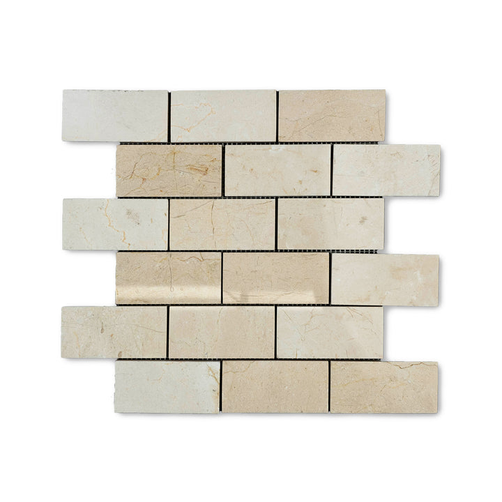 Top-down image of 2x4 Crema Marfil Marble brick mosaic in polished finish, reflecting light with its glossy texture and subtle veining.
