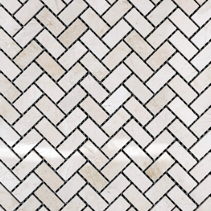 Polished 5/8x1-1/4 herringbone mosaic in Crema Marfil Marble, arranged in a woven overview to highlight its warm beige tones.