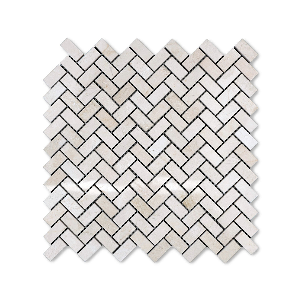 Polished 5/8 by 1-1/4 Crema Marfil Marble herringbone mosaic viewed from above, combining small-scale pattern with a glossy marble finish.