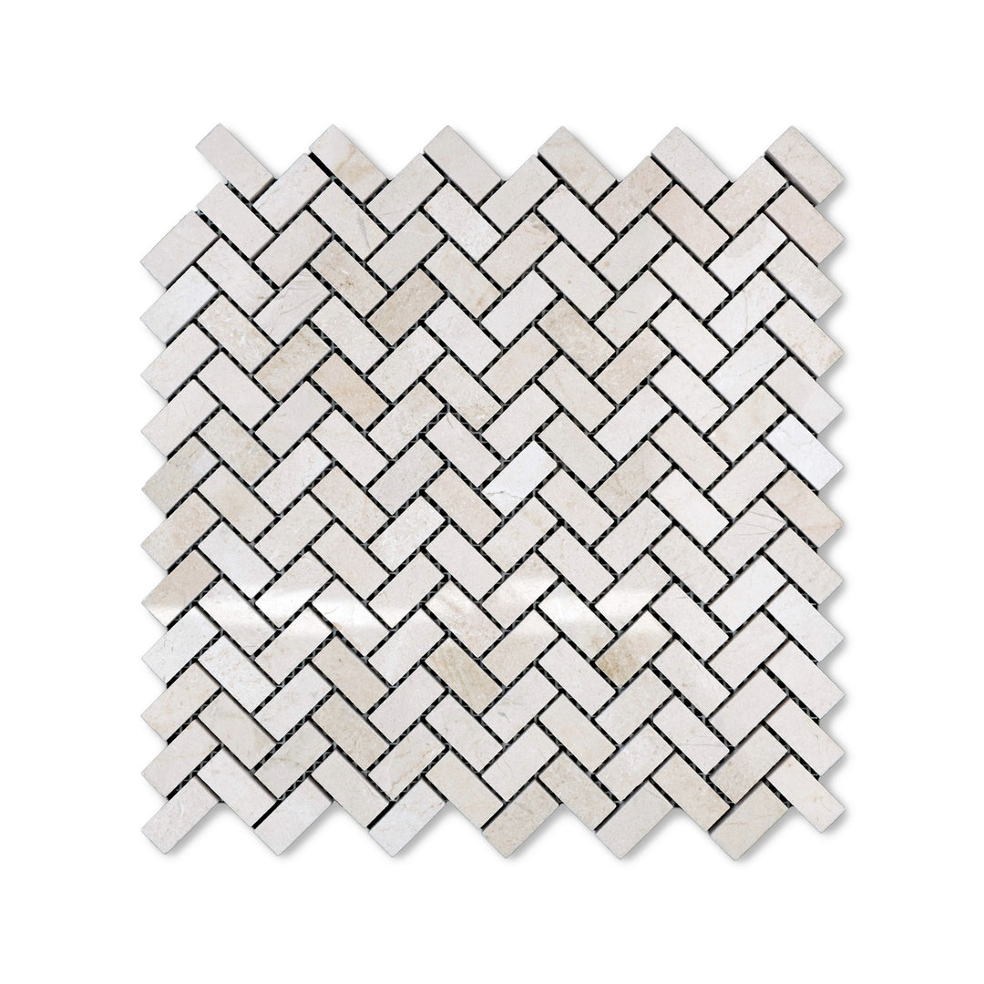 Polished 5/8 by 1-1/4 Crema Marfil Marble herringbone mosaic viewed from above, combining small-scale pattern with a glossy marble finish.