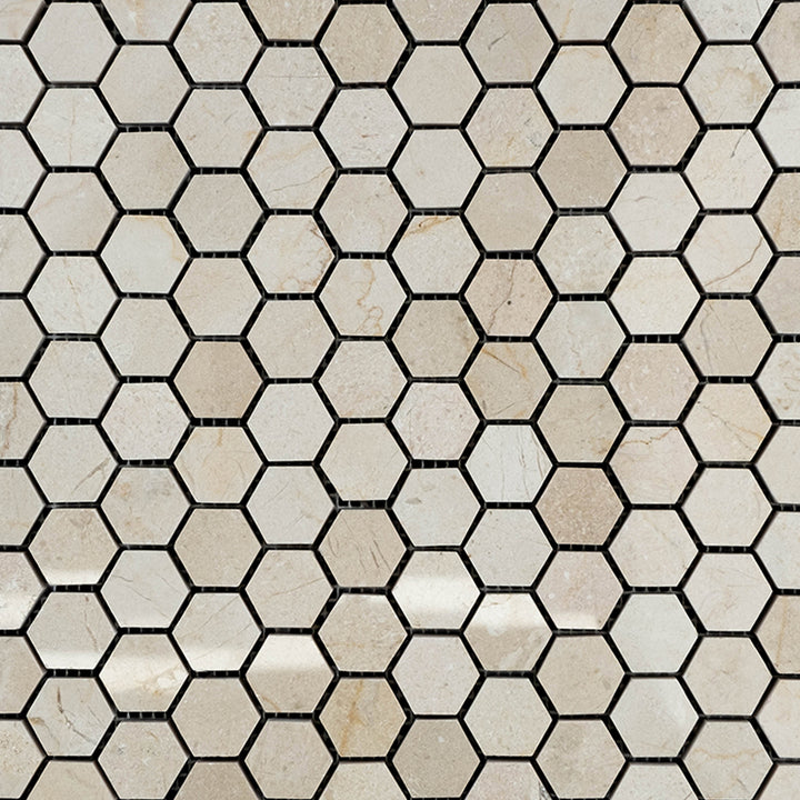 Polished 1" hexagon mosaic made from Crema Marfil Marble arranged in a honeycomb layout for visual continuity.