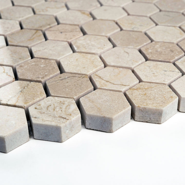 Polished 1 inch hexagon Crema Marfil mosaic seen from the side, featuring geometric precision and a glossy, light-catching finish.