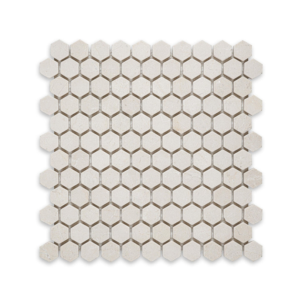 Overhead shot of Crema Marfil Marble 1 inch hexagon tumbled mosaic, featuring a rustic edge and soft texture for a naturally aged appearance.