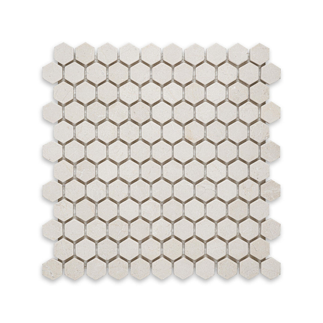 Overhead shot of Crema Marfil Marble 1 inch hexagon tumbled mosaic, featuring a rustic edge and soft texture for a naturally aged appearance.