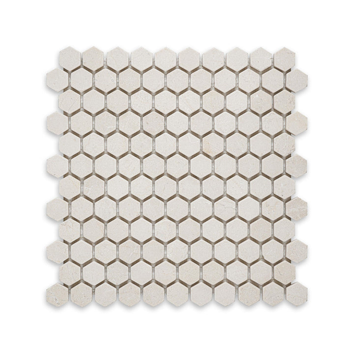 Overhead shot of Crema Marfil Marble 1 inch hexagon tumbled mosaic, featuring a rustic edge and soft texture for a naturally aged appearance.