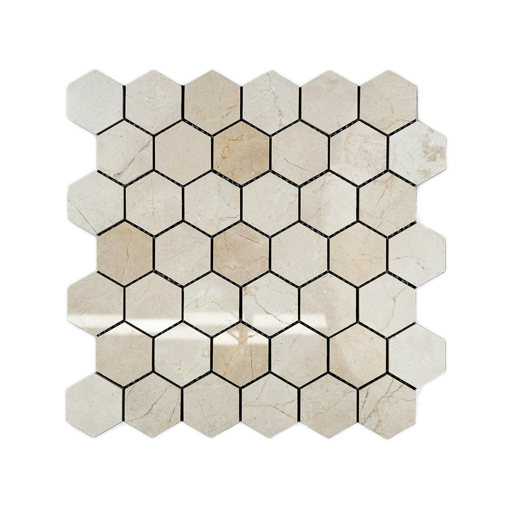 Top-down image of Crema Marfil Marble 2 inch hexagon mosaic in polished finish, featuring large format pieces with reflective shine and warm beige tones.
