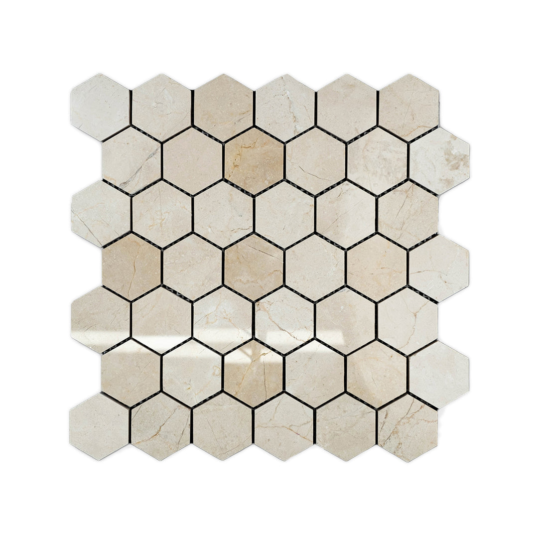 Top-down image of Crema Marfil Marble 2 inch hexagon mosaic in polished finish, featuring large format pieces with reflective shine and warm beige tones.