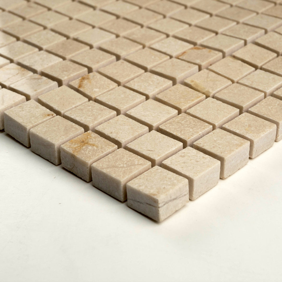 Polished 5/8 inch square Crema Marfil mosaic displayed at an angle to highlight its tiny format, glossy texture, and refined appearance.