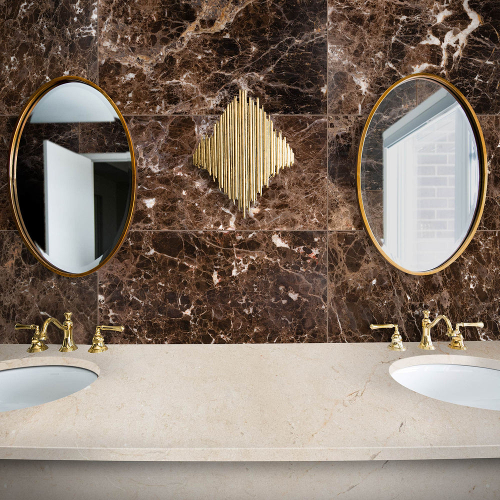 Bathroom vanity with marble countertop, dual sinks, and gold fixtures.