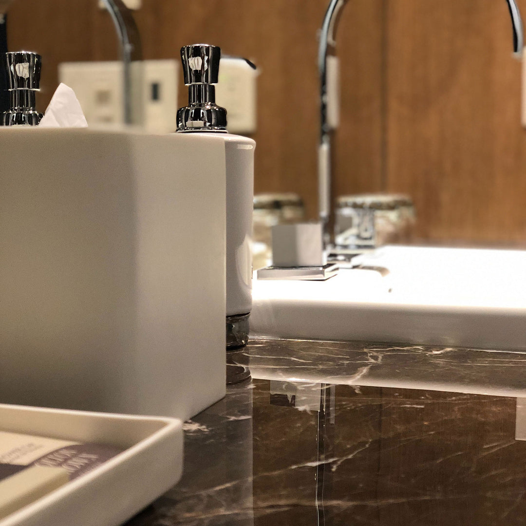 Bathroom sink with faucet and soap dispenser on a marble countertop